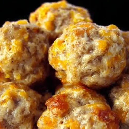 A serving platter filled with golden brown cream cheese sausage balls.