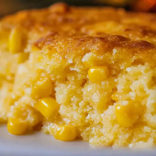 A golden-brown cornbread casserole in a rectangular baking dish.