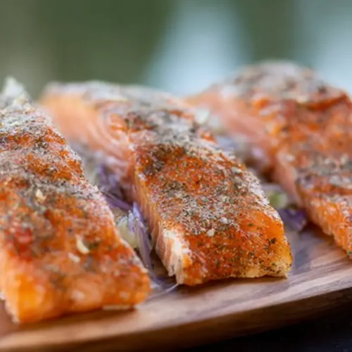 Close-up of thinly sliced smoked salmon on a bed of greens