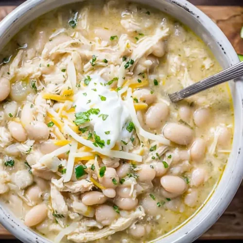 A hearty bowl of white chicken chili cooked in a slow cooker, ready to serve.