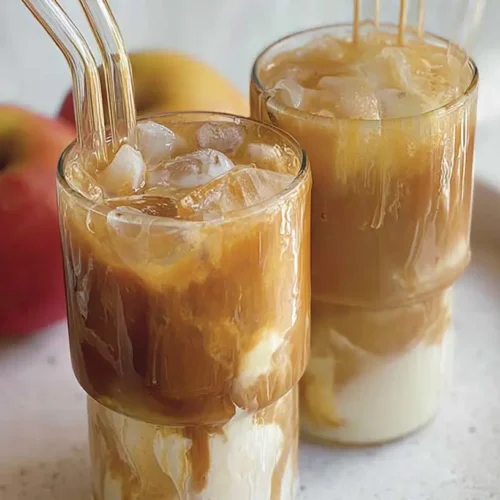 A tall glass of apple iced coffee with ice cubes