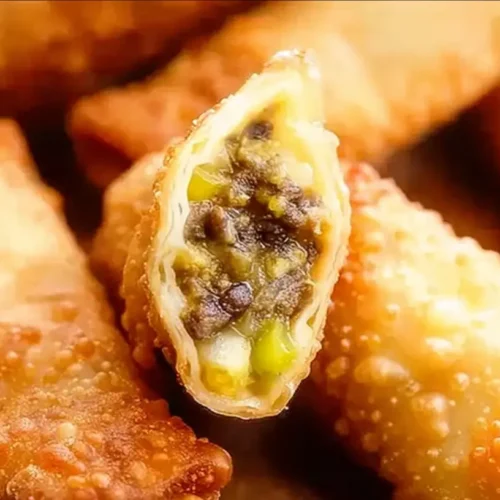 Stacked cheeseburger eggrolls on a white plate