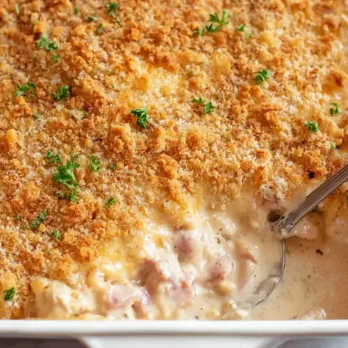 A bubbling chicken cordon bleu casserole topped with golden breadcrumbs