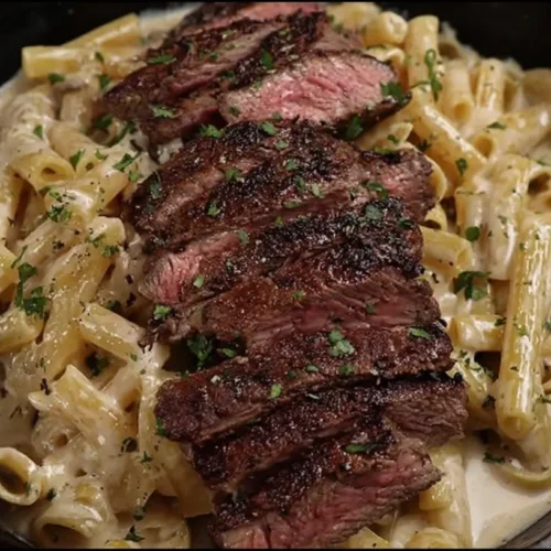 A plate of creamy ribeye steak pasta with herbs