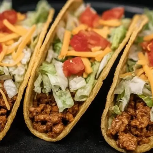 A serving of delicious crockpot tacos with fresh toppings.