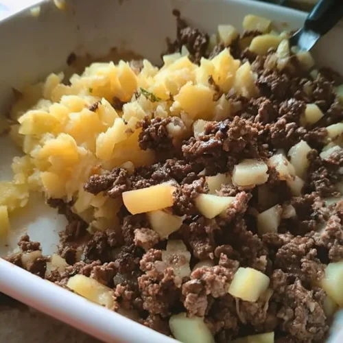 A close-up of a bubbling ground beef casserole with tender potatoes.