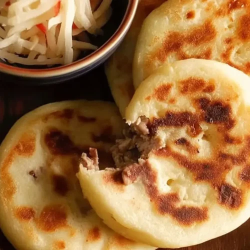 Freshly made homemade masa cheese pupusas on a griddle
