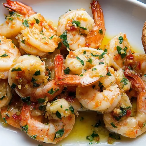 A close-up of a serving of shrimp scampi with pasta and parsley