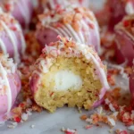 Individual strawberry cheesecake truffle balls on a silver tray