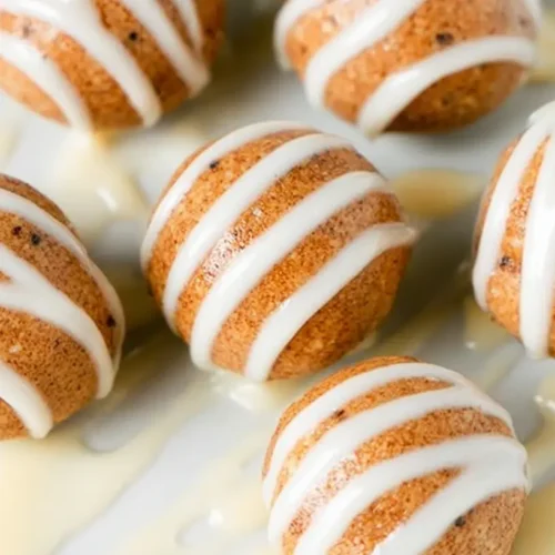 Small cinnamon roll protein bites drizzled with white icing
