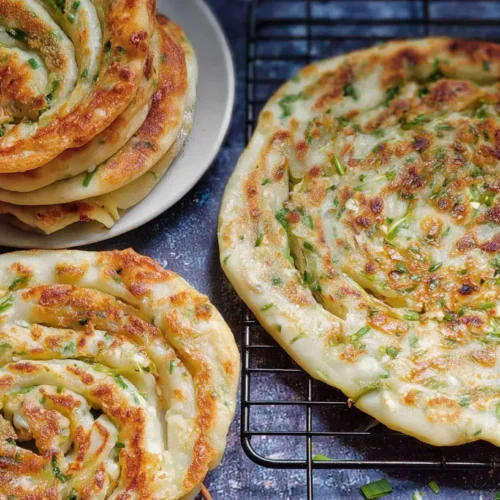 A close-up of crispy Chinese scallion pancakes with golden-brown edges.