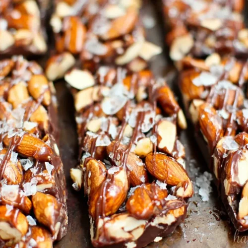 A close-up of dark chocolate and sea salt nut bars, showcasing the various nuts and chocolate drizzle.