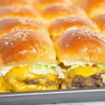 Several mini Big Mac sliders arranged neatly on a cutting board.