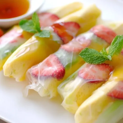 A platter of fresh fruit spring rolls with dipping sauce