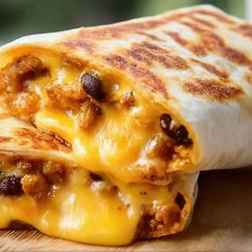 A mouthwatering grilled cheese burrito showing melted cheese inside.