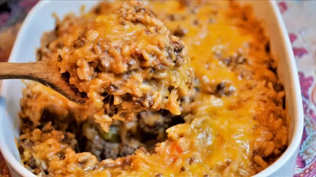 Golden-brown cheesy hamburger rice casserole in a ceramic dish