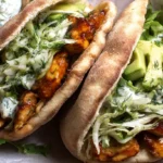 Baked sheet pan chicken and vegetables served with pita and herby ranch