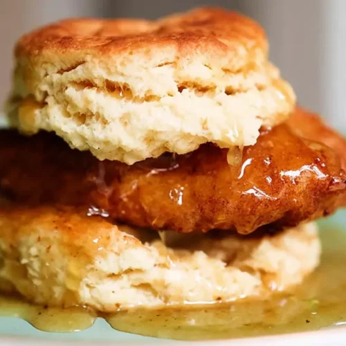 Hot honey chicken biscuits layered with golden fried chicken and a sweet spicy glaze