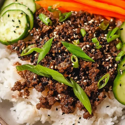 A delicious Korean Ground Beef Bowl topped with fresh green onions and sesame seeds, served in a ceramic bowl.