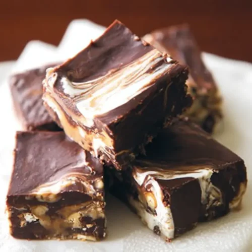 A rectangular slab of marshmallow swirl fudge with visible white marshmallow streaks