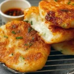 Several Korean Hotteok Potato Cheese Pancakes stacked on a plate, showing their crispy exterior.
