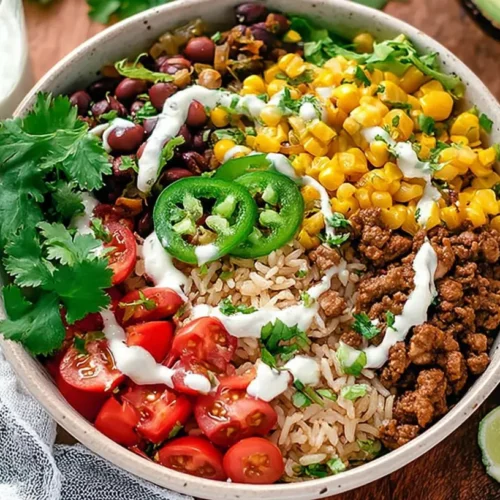 A vibrant taco rice bowl with seasoned ground beef, rice, and fresh toppings