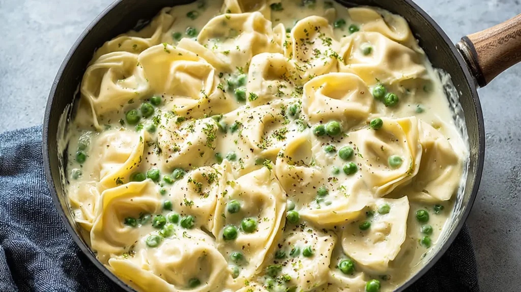 A serving of lemon ricotta tortellini with green peas and a rich sauce