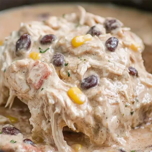 Creamy crockpot cream cheese chicken garnished with fresh herbs in a slow cooker.