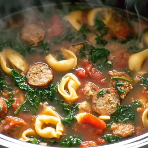 A comforting bowl of Crockpot Sausage and Kale Soup, rich with vegetables and broth.