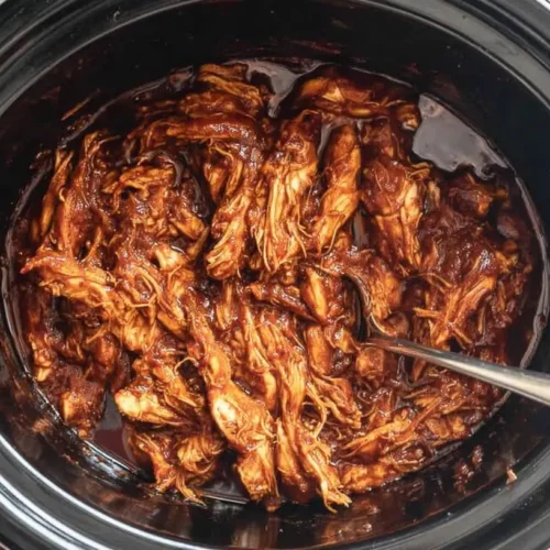 A serving of easy crockpot BBQ chicken, shredded and saucy, ready to eat.