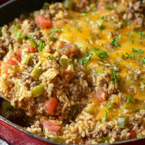 A steaming Easy Ground Beef and Rice Skillet meal with vegetables