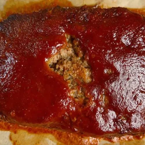 A serving of lean meatloaf with vegetable sides, ready for dinner.