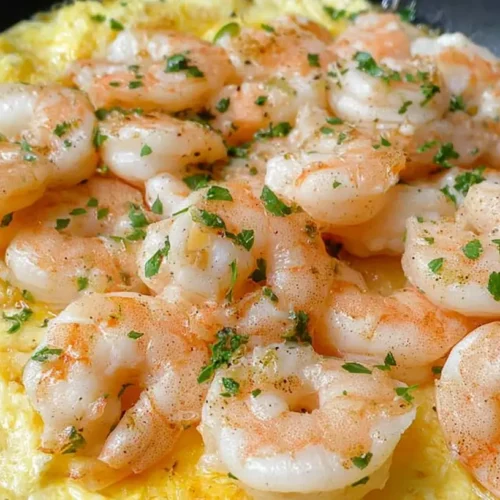 A serving of low-carb garlic shrimp dinner on a plate, garnished with fresh herbs.