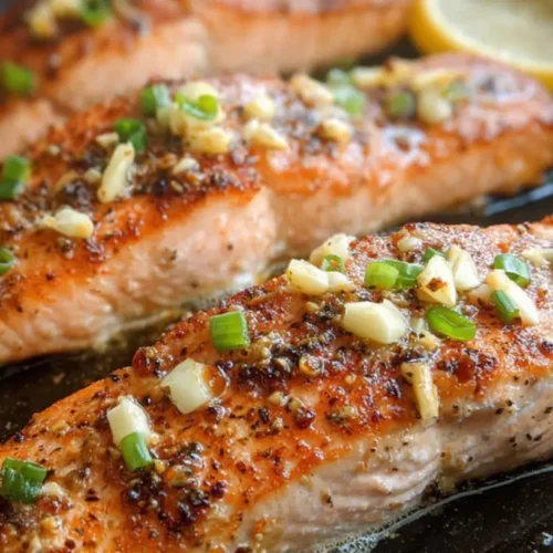 Pan seared salmon with garlic butter sauce, garnished with herbs