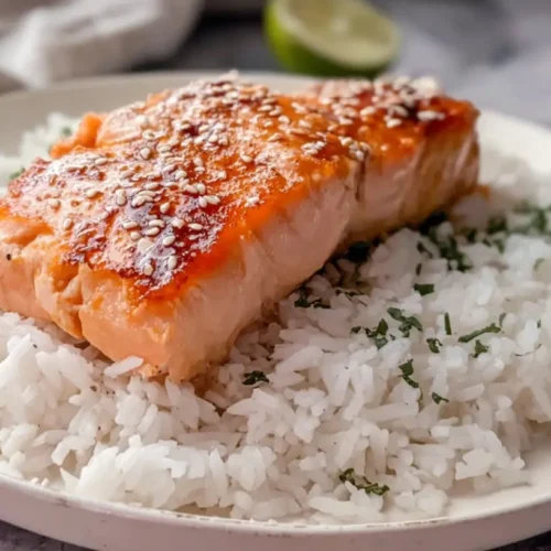 A serving of simple salmon with fluffy white rice on a plate