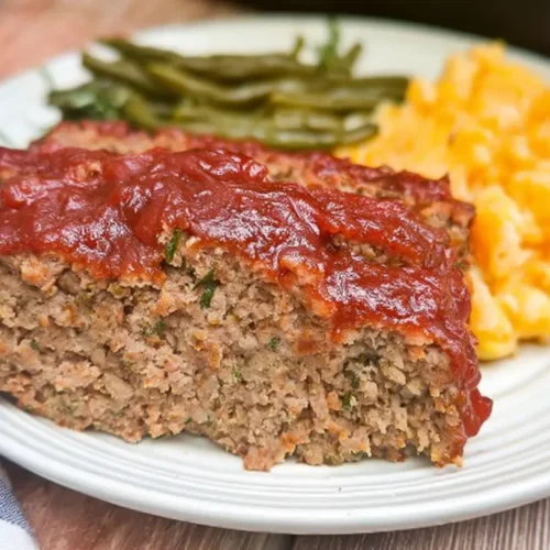 A traditional family meatloaf, perfectly baked and sliced on a serving platter.