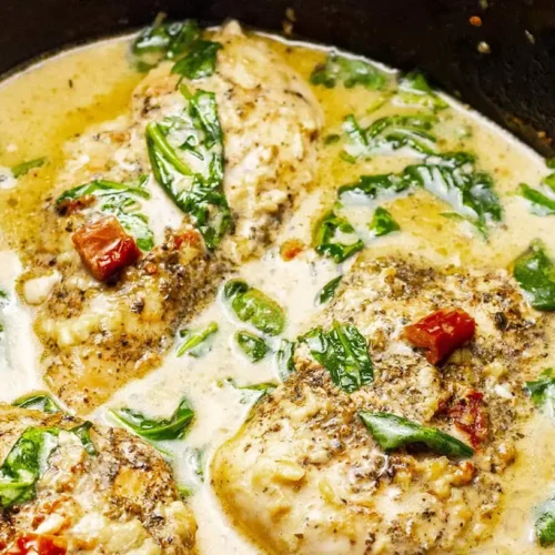 A creamy crockpot Tuscan chicken dish, rich with vibrant colors and herbs, ready to serve.