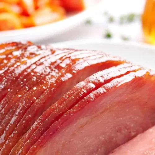 A perfectly cooked honey glazed ham, sliced and ready to serve.