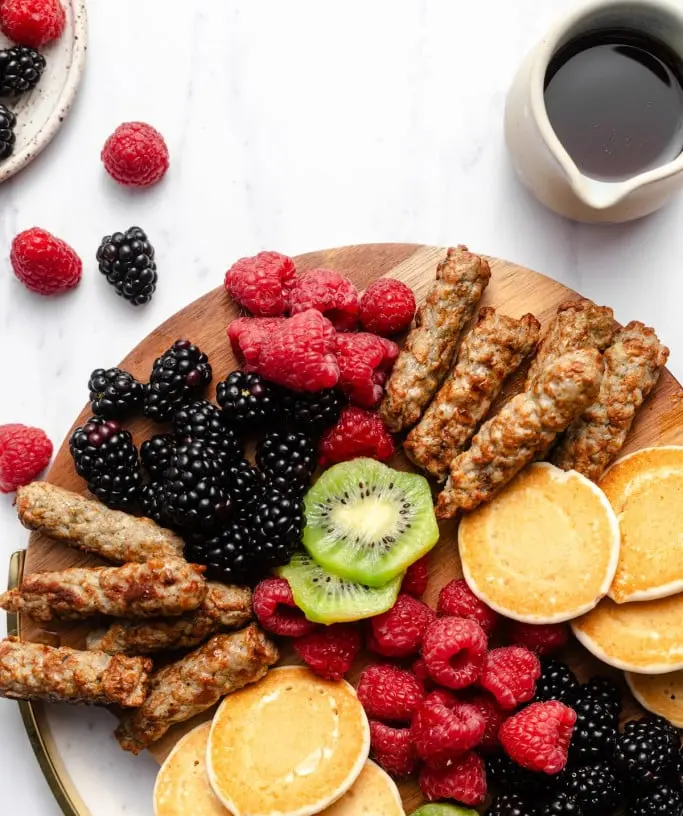 A table set with simple family breakfast items like toast, fruit, and eggs.