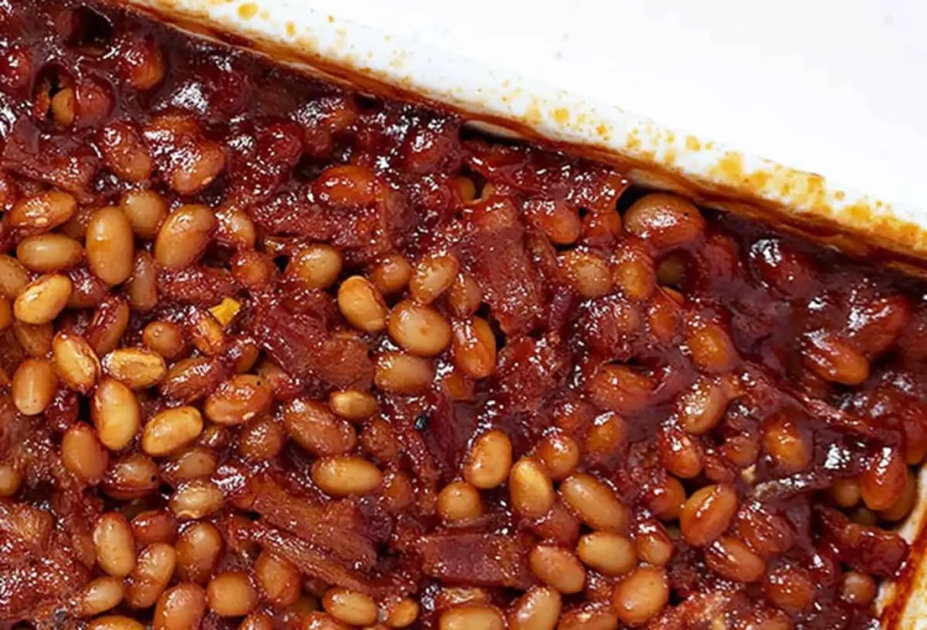 A serving of smoked baked beans with hearty bacon pieces mixed in.