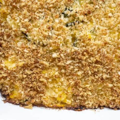 A baked squash zucchini casserole with golden-brown topping